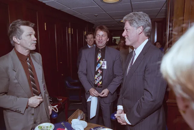 Tom Skerritt, with a mustache and a tan suit, talking with John Ritter and President Bill Clinton at the White House in 1993